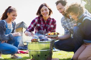 Family barbecuing at campsite grill