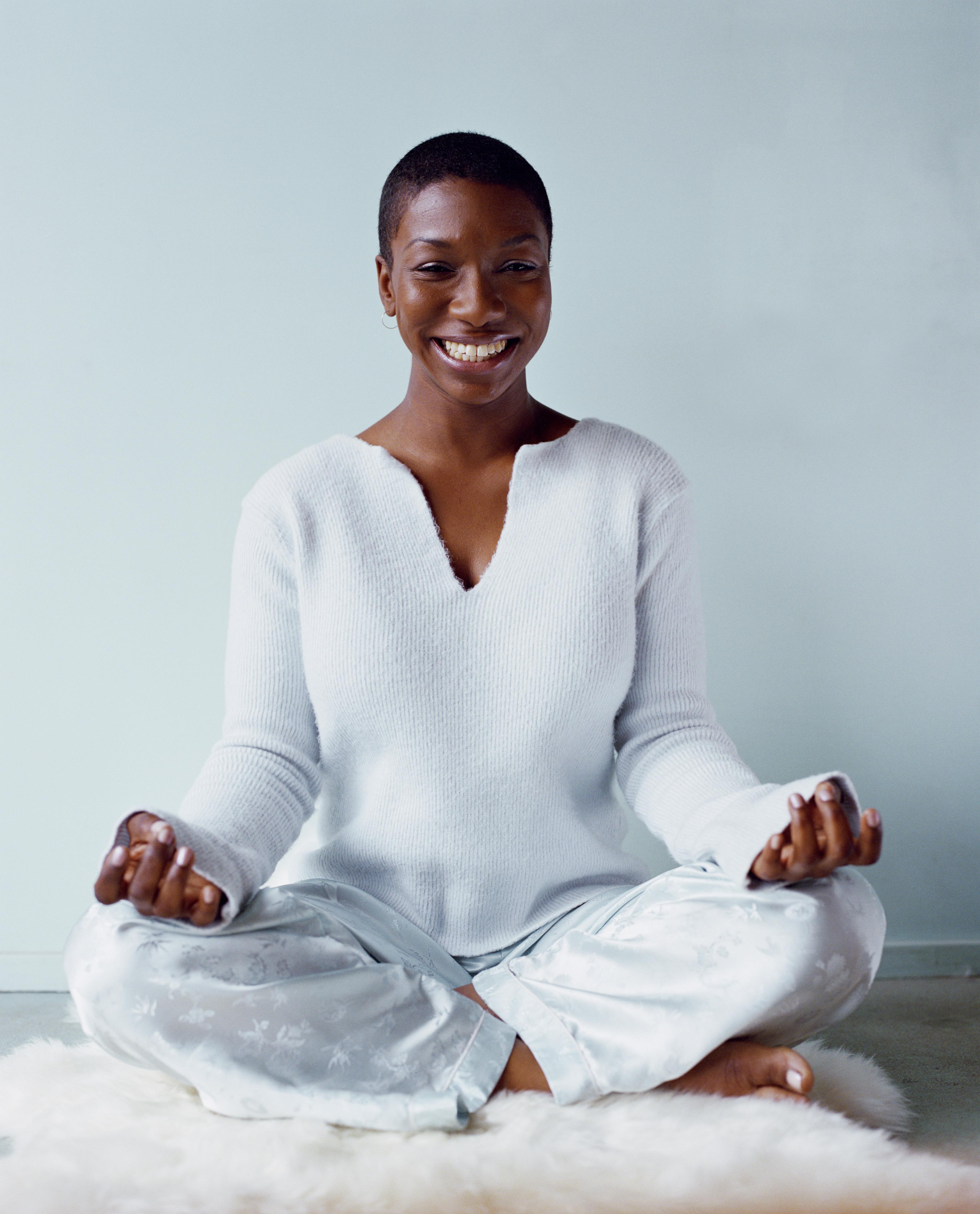 Woman in 'Lotus' meditation pose, smiling