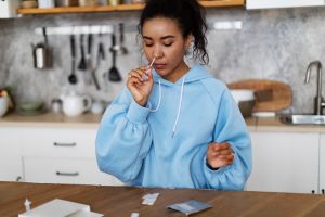 Young African woman making rapid test for covid-19 at home