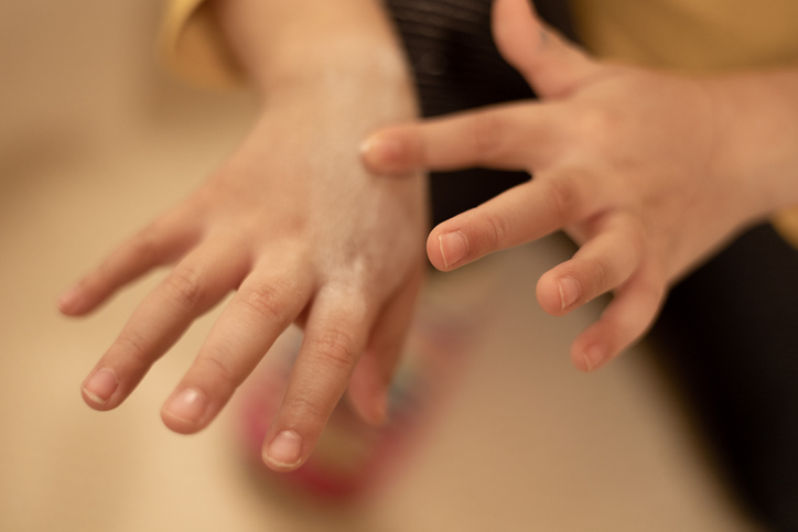 young mixed-race girl applying lotion to her hands