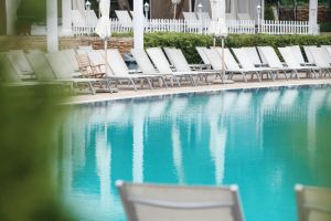 Empty Swimming Pool Public Area With White Tanning Beds On a Sunrise Moment