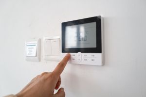 Hand pressing the air conditioner temperature adjustment switch