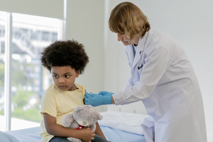 Little boy feeling pain while getting a vaccine