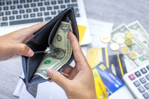 Poor man hand open wallet looking for money for credit card debt.