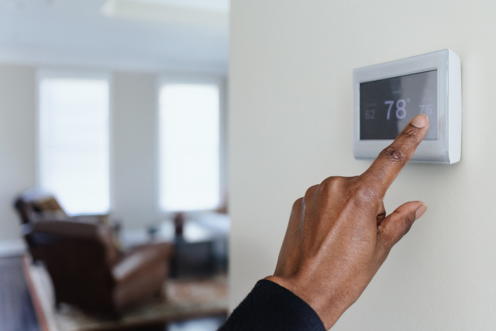 Woman Adjusts Thermostat