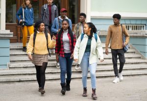 Female friends having fun walking together in campus