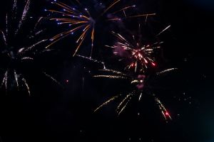 On a black background bokeh from explosions of colorful fireworks.