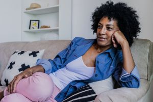 Mature woman watching TV in the living room at home