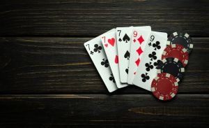 Combination of full house or full boat playing cards and winning chips on a black vintage table. Low key concept of winning combination in poker club or casino