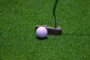 Golfer plays golf indoors on golf simulator