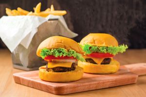 Beef Cheese Sliders with Lettuce, Jalapeno, Tomato, Cheese, Steak Slices isolated on wooden board with french fries basket side view of fastfood