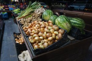 Night fruit and vegetable market. Crates filled with fresh products. Onions, watermelons, green onions, and potatoes.