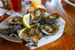 New Orleans, Louisiana in Mardi Gras Carnival Celebrations. Charbroiled Oysters with Lemon and Beer at a New Orleans Restaurant during Mardi Gras
