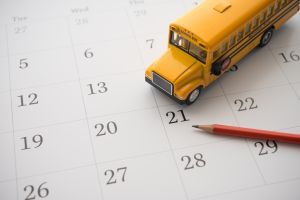 School bus, pencil on white blank calendar background copy space.