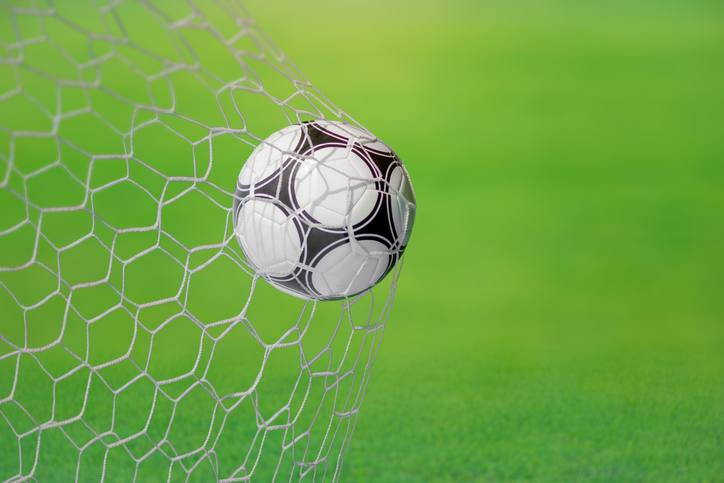 Kick the soccer ball into the soccer goal net. The surface of the soccer goal in a big stadium.