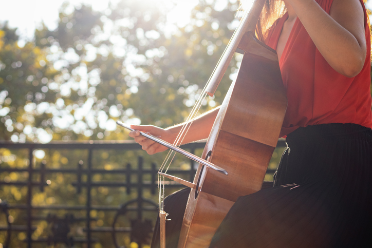 Cropped shot of an unrecognizable woman playing the cello outdoors
